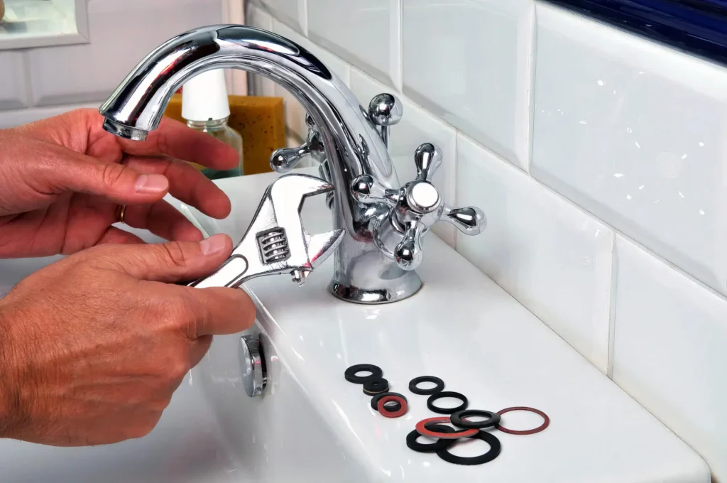 Plumber performing maintenance on a bathroom faucet in West Valley City