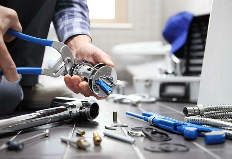 Technician repairing a plumbing fixture with professional tools in West Valley City