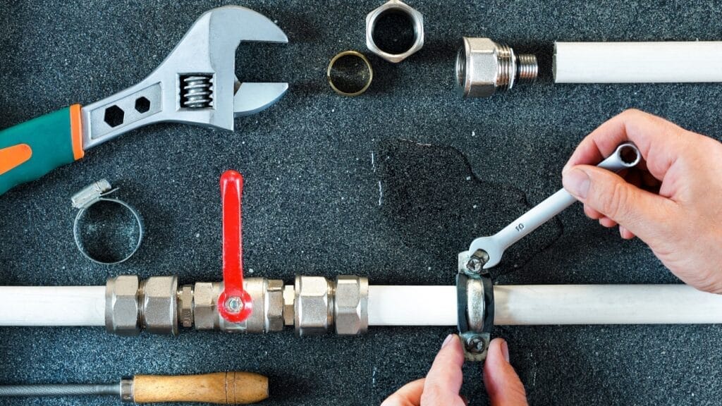 Plumbing tools and pipe fittings used for valve installation in West Valley City
