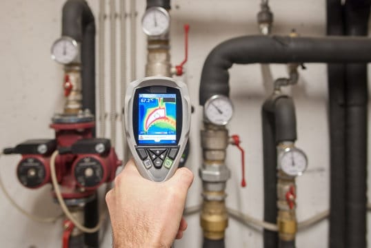 Plumber using a thermal imaging camera to inspect pipes in West Valley City