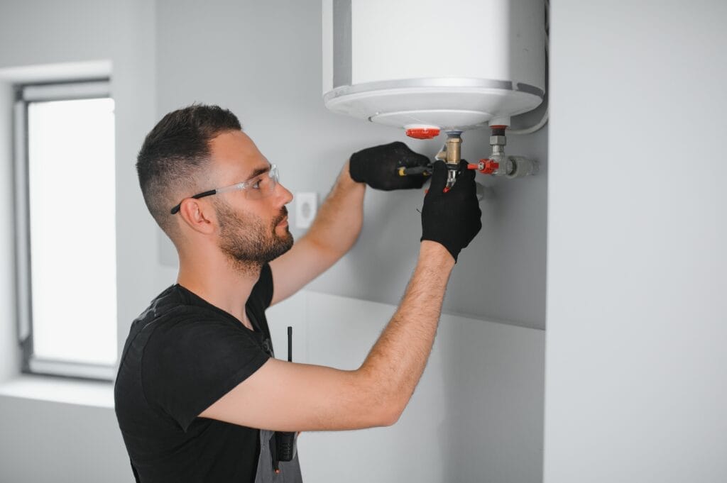 Technician performing water heater maintenance in West Valley City