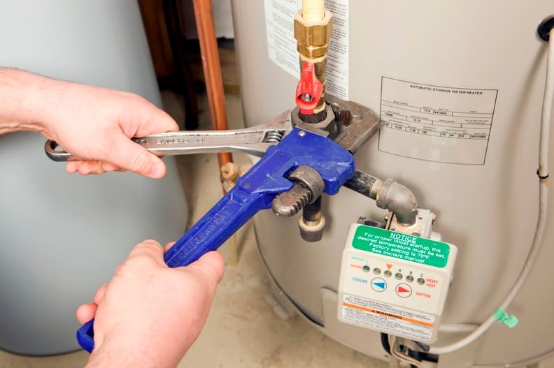 Plumber repairing a water heater valve in West Valley City